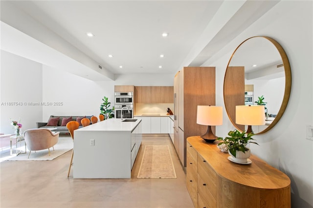 455 NE 39th St Unit 102, Miami, FL 33137 - kitchen featuring modern cabinets, light countertops, recessed lighting, a kitchen island with sink, and a breakfast bar area