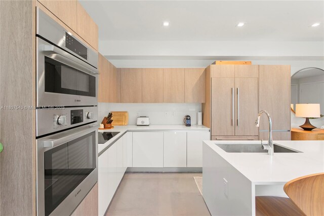 455 NE 39th St Unit 102, Miami, FL 33137 - kitchen featuring modern cabinets, a sink, light countertops, light brown cabinets, and recessed lighting