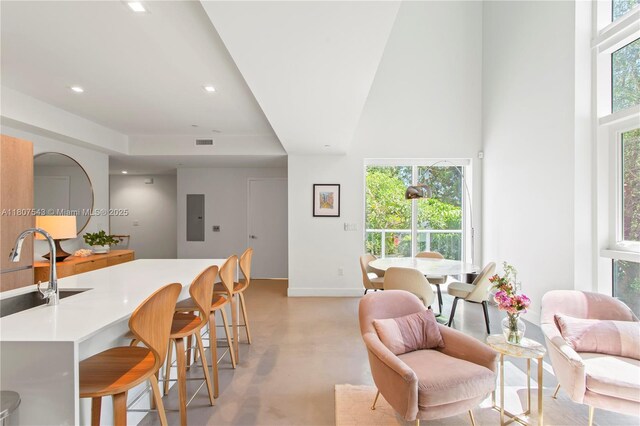 455 NE 39th St Unit 102, Miami, FL 33137 - living room featuring baseboards, a high ceiling, recessed lighting, electric panel, and concrete flooring