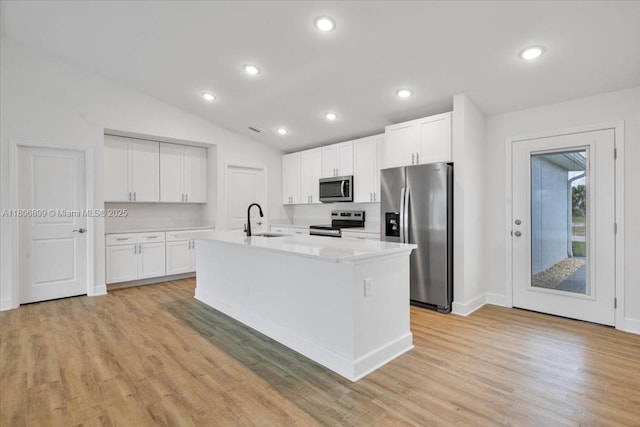 520 SW 28th St, Cape Coral, FL 33914 - kitchen featuring appliances with stainless steel finishes, lofted ceiling, light countertops, white cabinets, and light wood-style floors