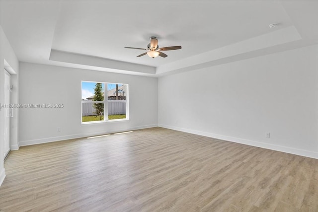 520 SW 28th St, Cape Coral, FL 33914 - spare room with a tray ceiling, a ceiling fan, light wood-style flooring, and a smoke detector