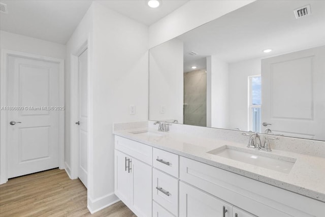 520 SW 28th St, Cape Coral, FL 33914 - full bath with double vanity, tiled shower, wood finished floors, and recessed lighting