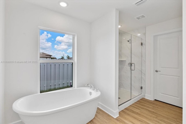 520 SW 28th St, Cape Coral, FL 33914 - bathroom with a freestanding bath, wood finished floors, a marble finish shower, and recessed lighting