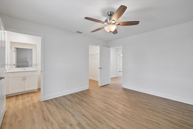 520 SW 28th St, Cape Coral, FL 33914 - unfurnished bedroom featuring light wood-style floors, a spacious closet, a closet, and connected bathroom