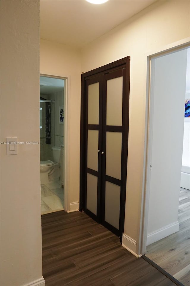 500 Three Islands Blvd Unit 106, Hallandale Beach, FL 33009 - hallway with dark wood-style floors and baseboards