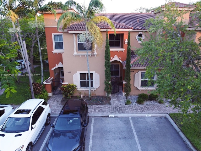 12154 SW 27th St Unit 1102, Miramar, FL 33025 - view of front of house featuring a tile roof, stucco siding, and uncovered parking