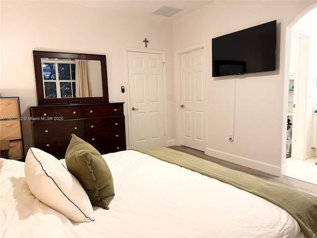 12154 SW 27th St Unit 1102, Miramar, FL 33025 - bedroom featuring arched walkways, wood finished floors, and baseboards