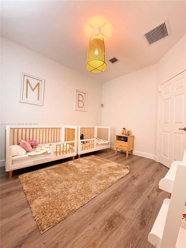 12154 SW 27th St Unit 1102, Miramar, FL 33025 - bedroom featuring wood finished floors, baseboards, and a nursery area