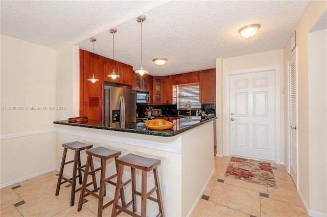 3051 NE 48th St Unit 604, Fort Lauderdale, FL 33308 - kitchen featuring appliances with stainless steel finishes, glass insert cabinets, a sink, a peninsula, and a kitchen bar