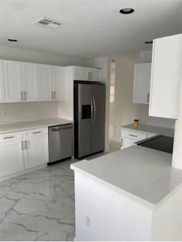 16461 SW 100th Ter, Miami, FL 33196 - kitchen with appliances with stainless steel finishes, white cabinetry, light marble finish floors, a peninsula, and recessed lighting