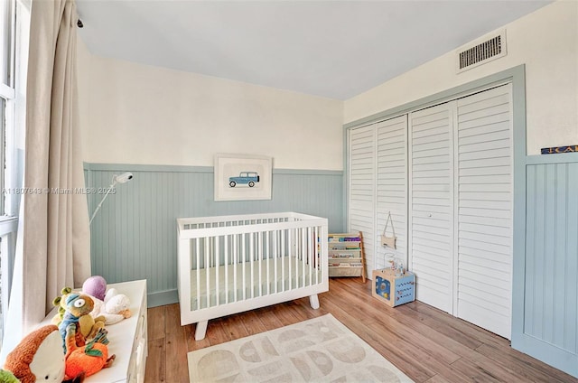 2055 SW 122nd Ave Unit 524, Miami, FL 33175 - bedroom with wainscoting, wood finished floors, a crib, and a closet