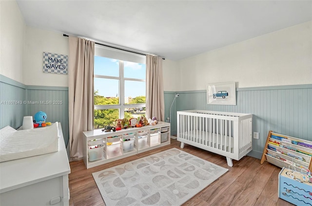 2055 SW 122nd Ave Unit 524, Miami, FL 33175 - bedroom featuring wainscoting, a nursery area, and wood finished floors