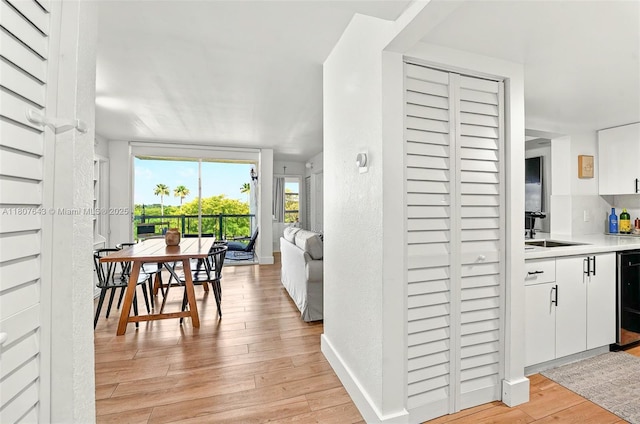 2055 SW 122nd Ave Unit 524, Miami, FL 33175 - kitchen featuring a sink, light wood-type flooring, white cabinets, and light countertops