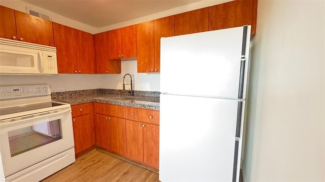 11195 SW 1st St Unit 319, Sweetwater, FL 33174 - kitchen with white appliances, a sink, light wood finished floors, dark countertops, and brown cabinetry