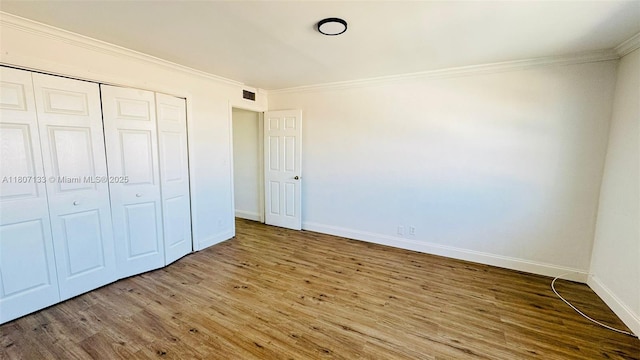 11195 SW 1st St Unit 319, Sweetwater, FL 33174 - unfurnished bedroom featuring wood finished floors, crown molding, baseboards, and a closet