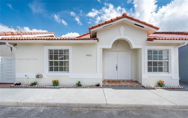 9021 NW 121st Ter Unit 85, Hialeah Gardens, FL 33018 - view of front of home with a tiled roof and stucco siding