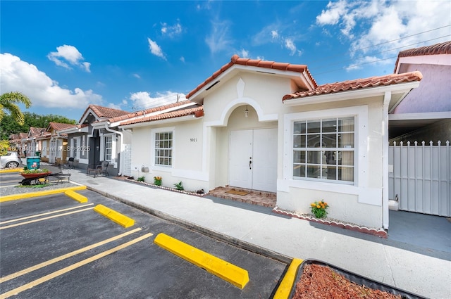 9021 NW 121st Ter Unit 85, Hialeah Gardens, FL 33018 - mediterranean / spanish home featuring a tile roof, stucco siding, and uncovered parking