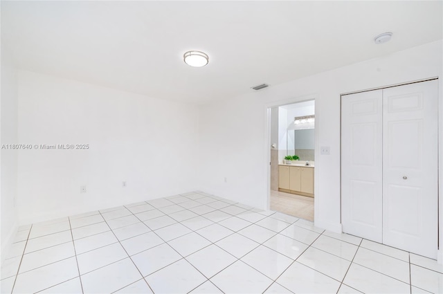 9021 NW 121st Ter Unit 85, Hialeah Gardens, FL 33018 - unfurnished bedroom with a closet, light tile patterned floors, and ensuite bath