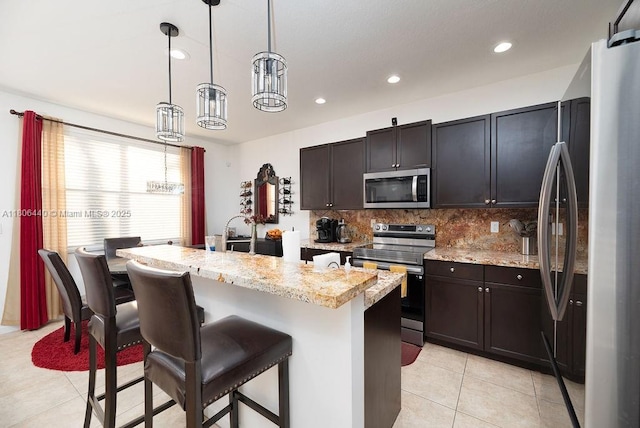 4832 SW 159th Ave, Miramar, FL 33027 - kitchen with appliances with stainless steel finishes, light tile patterned flooring, a breakfast bar, tasteful backsplash, and recessed lighting