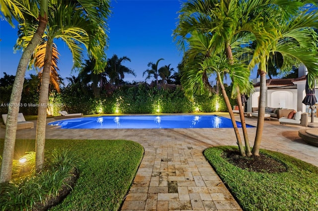 321 SW 1st Ave, Boynton Beach, FL 33435 - pool at night with an outdoor hangout area, a patio area, and an outdoor pool