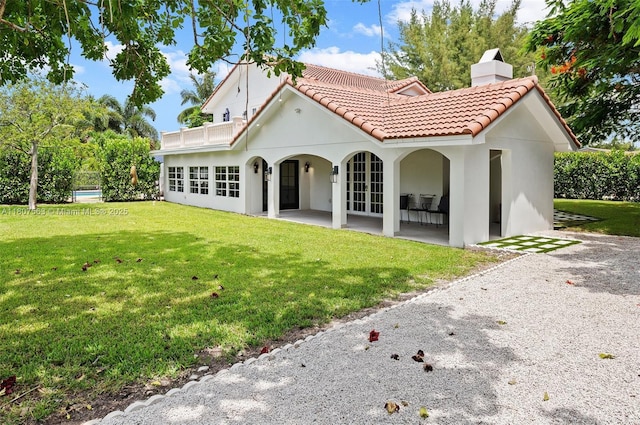 321 SW 1st Ave, Boynton Beach, FL 33435 - rear view of house with a tile roof, a yard, and stucco siding