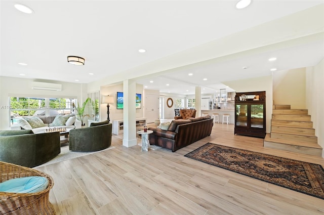 321 SW 1st Ave, Boynton Beach, FL 33435 - living room featuring a wall mounted AC, stairway, recessed lighting, and light wood-style flooring