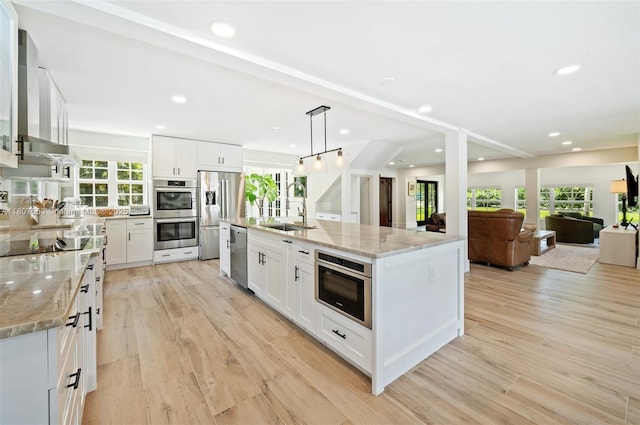 321 SW 1st Ave, Boynton Beach, FL 33435 - kitchen featuring stainless steel appliances, wall chimney exhaust hood, recessed lighting, plenty of natural light, and white cabinetry