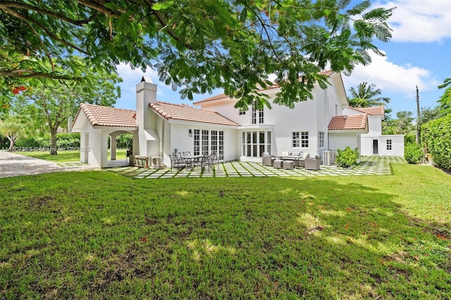 321 SW 1st Ave, Boynton Beach, FL 33435 - rear view of property with a chimney, a tiled roof, an outdoor hangout area, a yard, and stucco siding