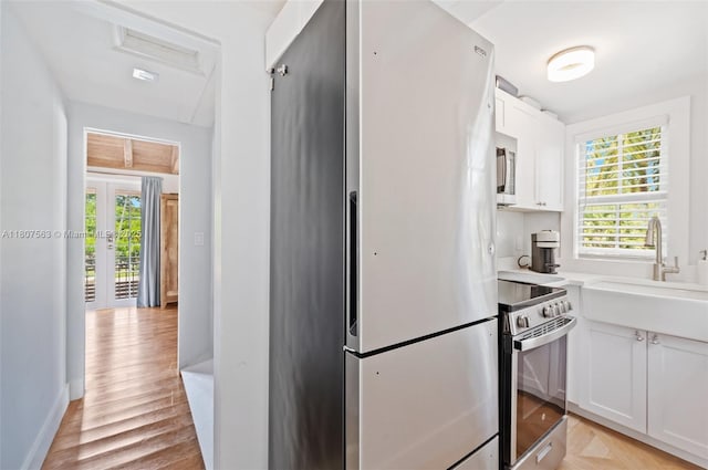321 SW 1st Ave, Boynton Beach, FL 33435 - kitchen featuring appliances with stainless steel finishes, plenty of natural light, white cabinets, and light countertops