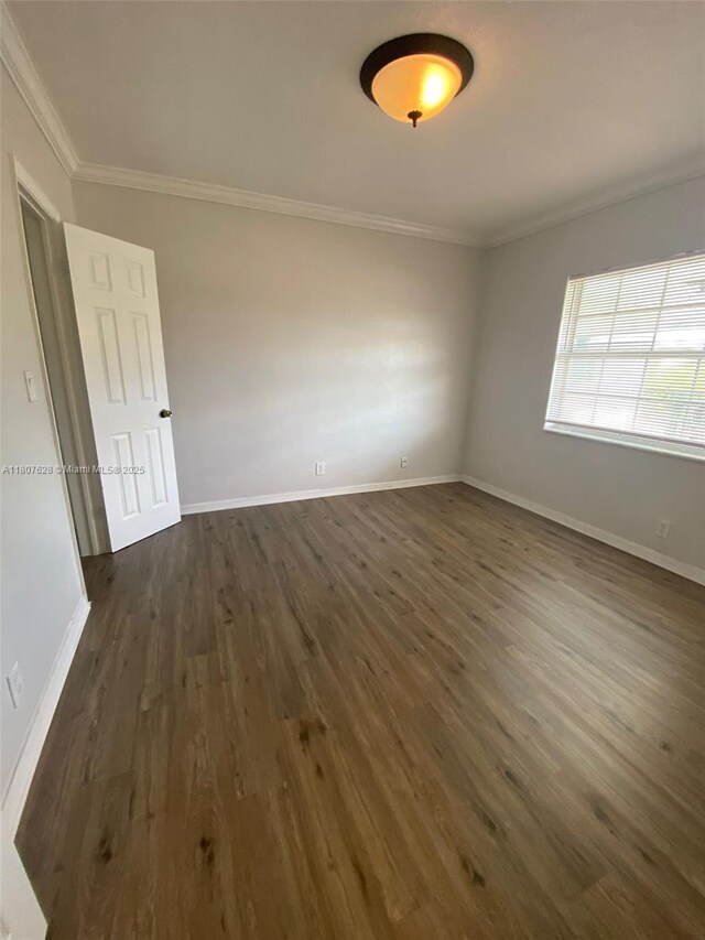 4291 NW 9th Ave Unit 202, Deerfield Beach, FL 33064 - empty room featuring crown molding, dark wood-style floors, and baseboards