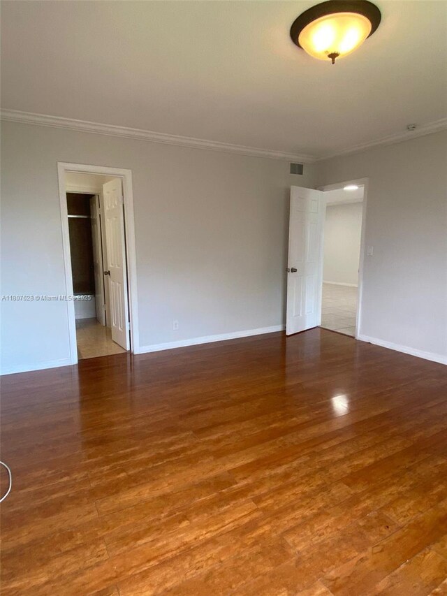 4291 NW 9th Ave Unit 202, Deerfield Beach, FL 33064 - spare room featuring ornamental molding, wood finished floors, and baseboards