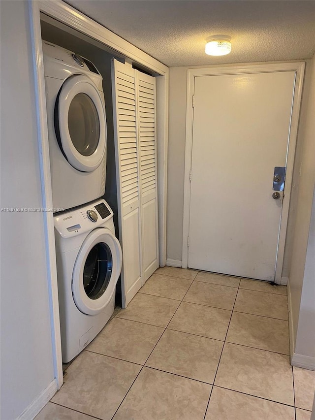 4291 NW 9th Ave Unit 202, Deerfield Beach, FL 33064 - laundry room with estacked washer and dryer, a textured ceiling, and light tile patterned flooring