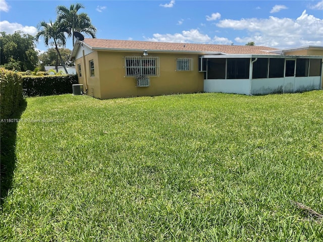 11753 SW 32nd St, Miami, FL 33175 - rear view of house with a sunroom, stucco siding, a yard, and cooling unit