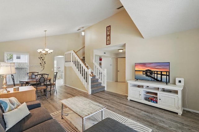 879 Matt Ln, Port Orange, FL 32127 - living room with stairway, a chandelier, wood finished floors, high vaulted ceiling, and baseboards