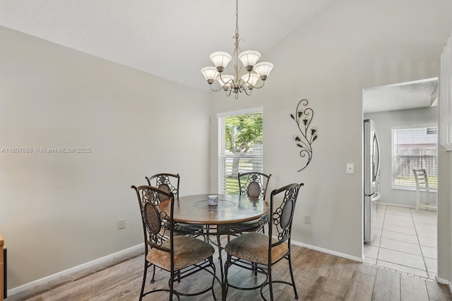 879 Matt Ln, Port Orange, FL 32127 - dining room featuring light wood-style flooring, a chandelier, baseboards, and lofted ceiling