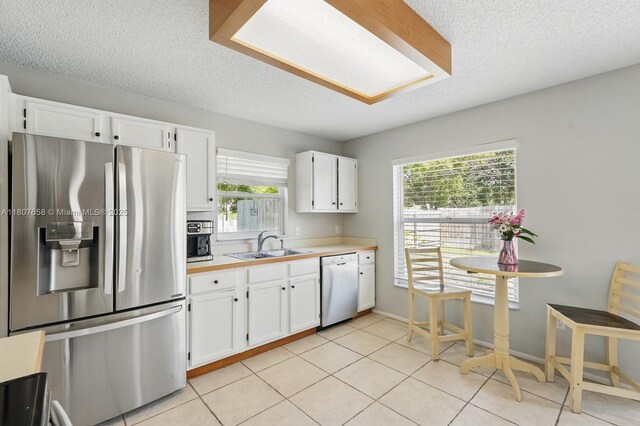 879 Matt Ln, Port Orange, FL 32127 - kitchen with stainless steel refrigerator with ice dispenser, dishwashing machine, a textured ceiling, healthy amount of natural light, and light countertops