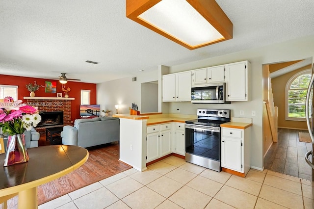 879 Matt Ln, Port Orange, FL 32127 - kitchen featuring appliances with stainless steel finishes, a peninsula, open floor plan, ceiling fan, and a textured ceiling
