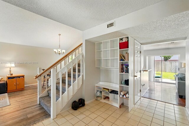 879 Matt Ln, Port Orange, FL 32127 - stairway with a textured ceiling, a chandelier, baseboards, and lofted ceiling