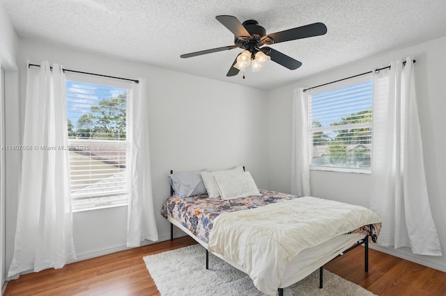 879 Matt Ln, Port Orange, FL 32127 - bedroom featuring multiple windows, wood finished floors, a textured ceiling, and ceiling fan