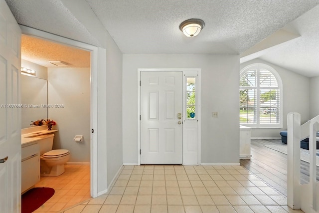 879 Matt Ln, Port Orange, FL 32127 - entryway with a textured ceiling, baseboards, light tile patterned floors, and vaulted ceiling