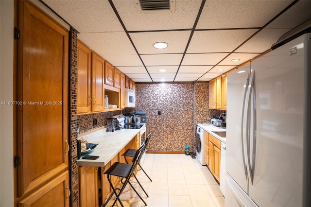 2101 Atlantic Shores Blvd Unit 120, Hallandale Beach, FL 33009 - kitchen with white appliances, washer / dryer, a drop ceiling, recessed lighting, and light countertops