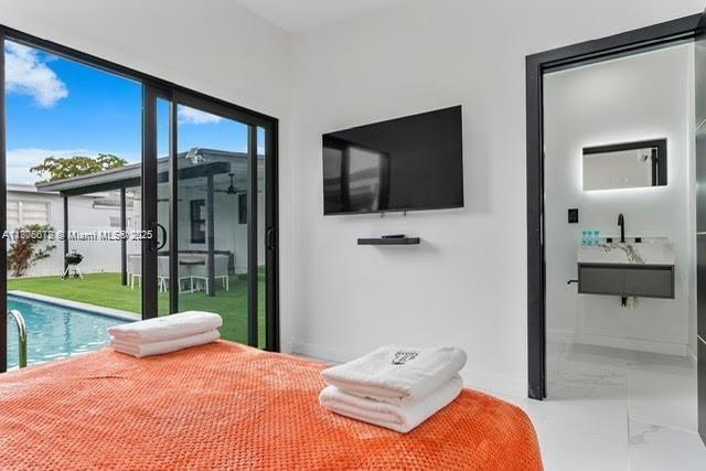 4861 SW 5th St, Miami, FL 33134 - bedroom with marble tiled flooring, access to outside, a sink, and baseboards