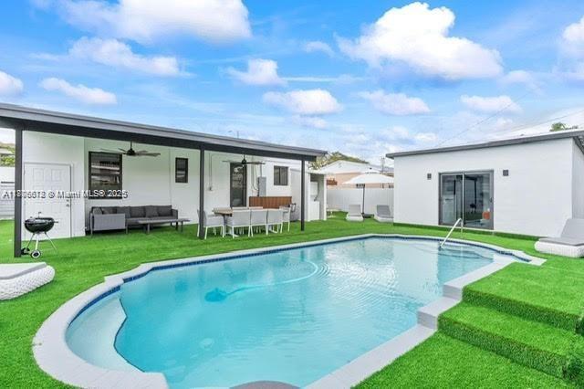 4861 SW 5th St, Miami, FL 33134 - back of property with a ceiling fan, outdoor lounge area, a lawn, and an outdoor pool