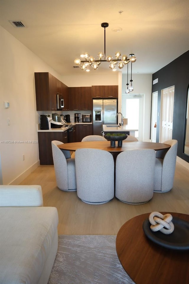 8201 NW 41st St Unit D-402, Doral, FL 33166 - dining room with a chandelier, baseboards, and light wood-style floors