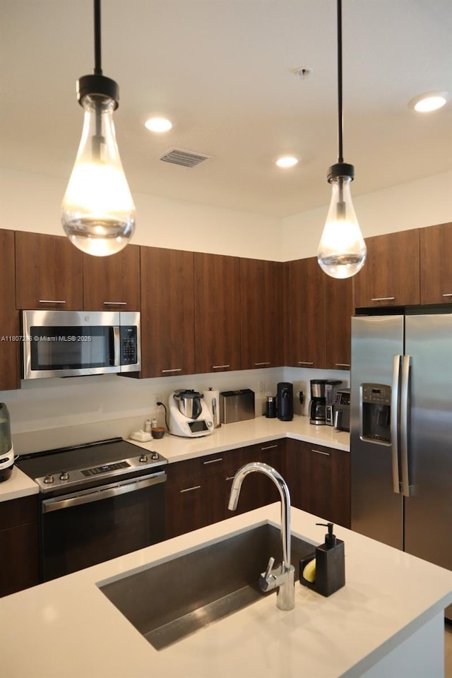 8201 NW 41st St Unit D-402, Doral, FL 33166 - kitchen with appliances with stainless steel finishes, light countertops, a sink, hanging light fixtures, and modern cabinets