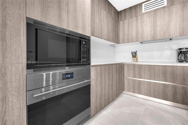 17550 Collins Ave Unit 603, Sunny Isles Beach, FL 33160 - kitchen featuring oven, modern cabinets, black microwave, and light countertops