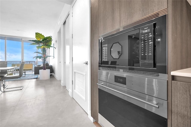 17550 Collins Ave Unit 603, Sunny Isles Beach, FL 33160 - kitchen view of stainless steel oven, black microwave, modern cabinets, and baseboards