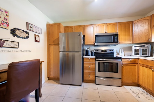 9823 S Hollybrook Lake Dr Unit 105, Pembroke Pines, FL 33025 - kitchen with appliances with stainless steel finishes, light tile patterned floors, light countertops, and brown cabinets