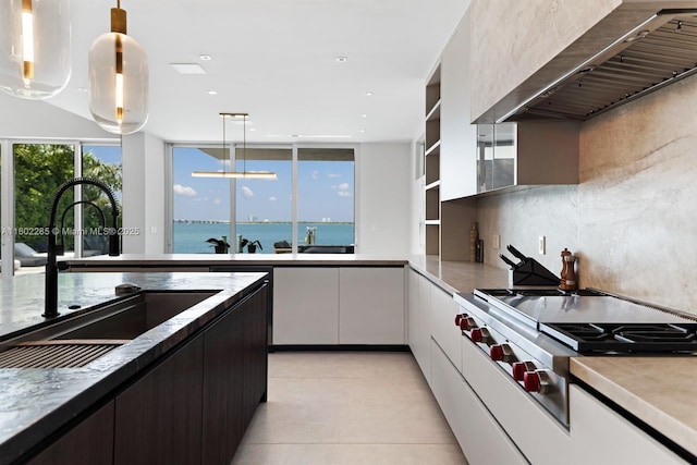 1379 N Venetian Way, Miami, FL 33139 - kitchen featuring stainless steel gas stovetop, wall chimney exhaust hood, a sink, white cabinetry, and hanging light fixtures