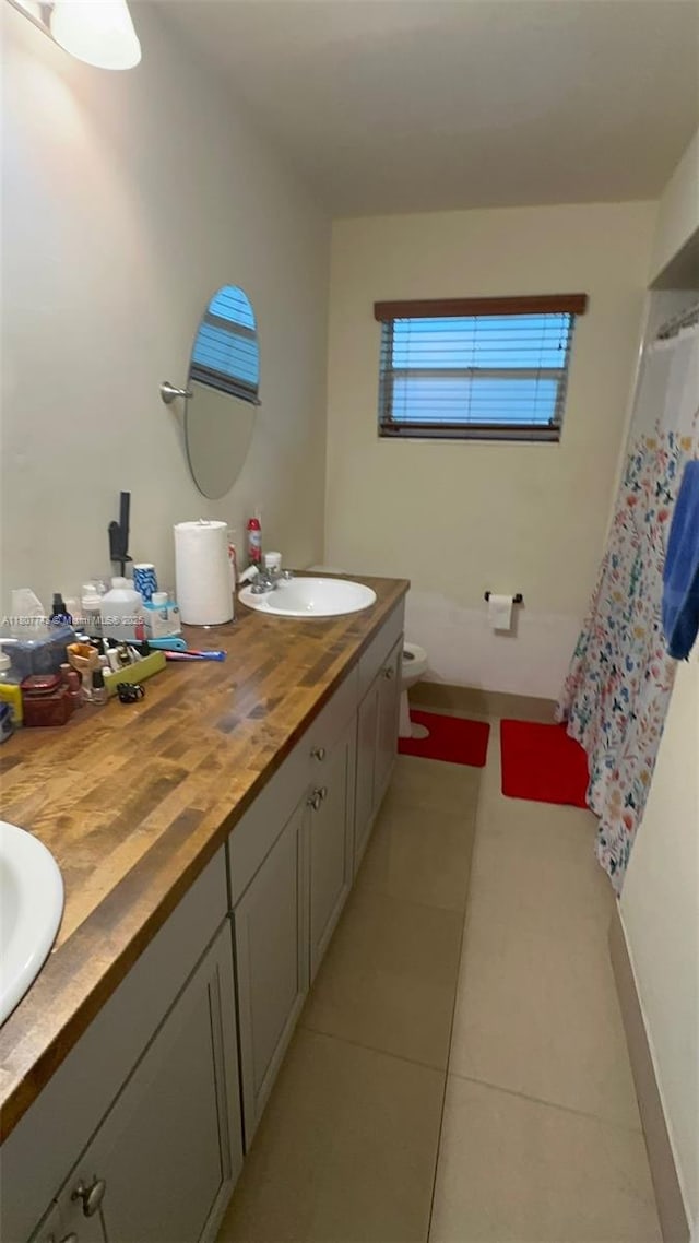2301 NW 43rd Ter, Lauderhill, FL 33313 - full bath featuring tile patterned floors, double vanity, toilet, baseboards, and a shower with shower curtain